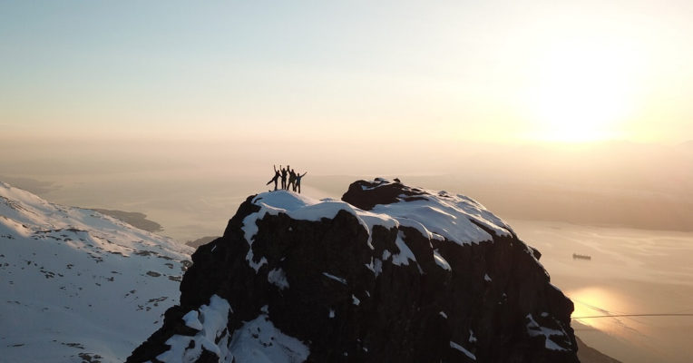 Glückliche Menschen auf einem Berg bei Sonnenaufgang
